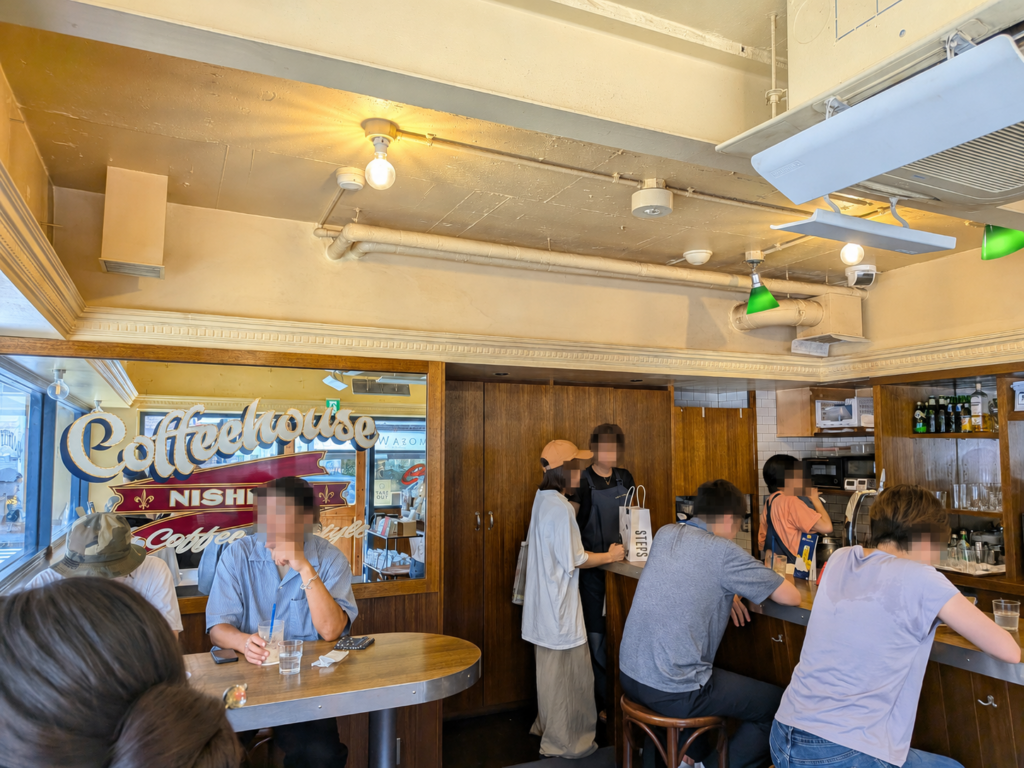 渋谷駅から徒歩約8分。REC COFFEE 渋谷東店は、COFFEEHOUSE NISHIYAの空気を受け継ぐスペシャルティコーヒーショップ。木の温もりある店内と丁寧な一杯を、MOZiが紹介します。