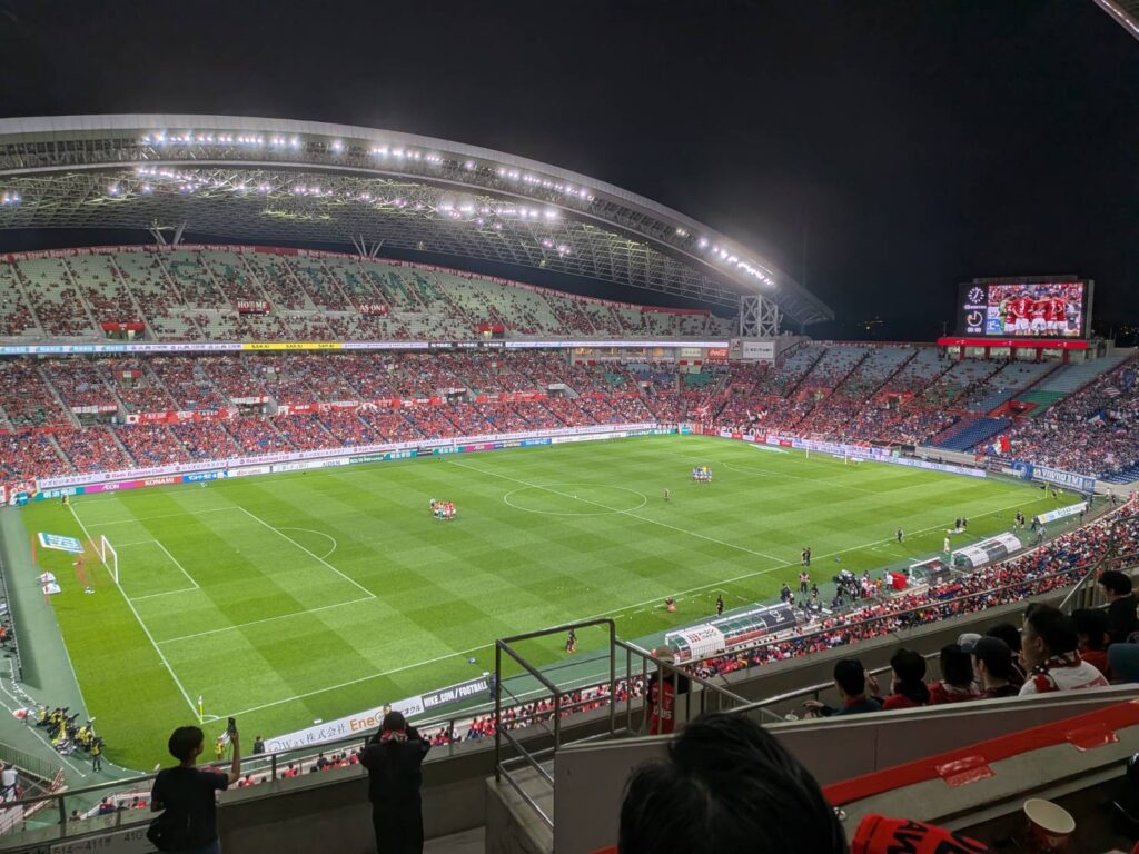 浦和レッズと横浜F・マリノスの一戦を埼玉スタジアム2002で現地観戦。2度リードを許しながら3-2で逆転勝利を飾った浦和。夜のスタジアムの熱気や赤く染まるスタンドとともに、現地観戦の魅力をMOZiらしい視点で綴ります。